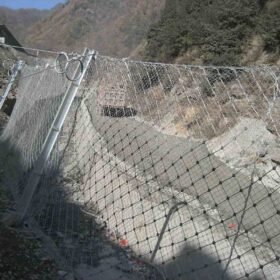 Steel wire rope net na may chain link fence na naka install sa ibaba ng bundok para sa proteksyon sa kalsada.